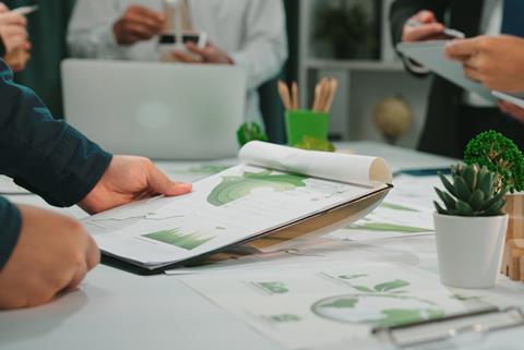 Close up on a green chart on a clip board in a meeting discussing environmental aspects of a project.